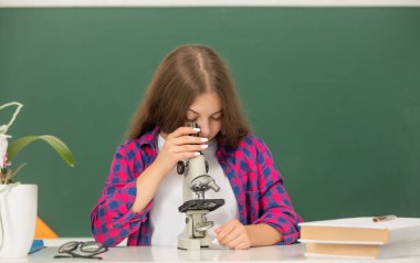 Karatahta arka planında mikroskop olan çocuk çalışmaları, bilim