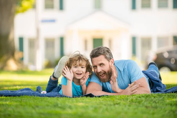 가족의 가치. 어린 시절 과 부모가 되는 것. 부모는 풀밭에 있는 어린 아들 과 함께 긴장을 풀라. — 스톡 사진