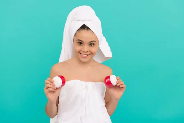 Happy teen girl in bath tower presenting body cosmetic, beauty — Stock Photo, Image