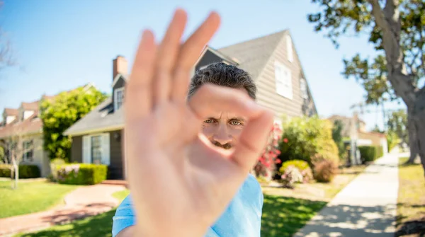 Ok gesture close seup of unshaven guy standing near new house, ok — стоковое фото