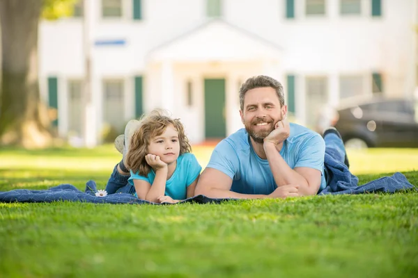 밝은 아버지와 자녀가 함께 푸른 공원 풀에서 휴식을 취하는 모습, 부모 노릇을 하는 모습 — 스톡 사진