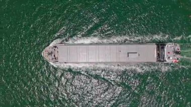 Konteyner gemisi. İhraç ve ithalat. Kargo işi. Boş mavna. Denizde konteynırı olan kargo gemisi, hava manzaralı. Konteynır için kargo gemisi. Kargo gemisi limandan ayrılıyor. Ticari ulaşım.