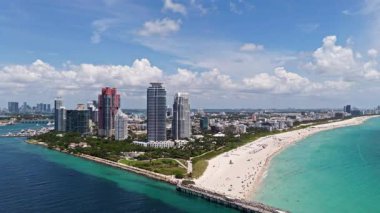 Miami 'de kumsalda güneşli yataklı, okyanus dalgalı bir plaj. Muhteşem manzaralı Miami Beach cenneti. Güney Sahili Miami cankurtaranı. Miami 'de huzurlu deniz kenarı inzivası