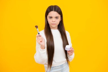 12, 13, 14 yaşlarında pudra ve fırçayla güzellik yapan bir kız çocuğu. Makyaj yapan güzel genç.