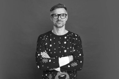 Kış süveteri ve gözlüklü gülen adam. Xmas elemanı kırmızı arka planda el ele vermiş. Mutlu yıllar. Mutlu Noeller..