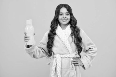 Genç kız su şişesini sarı arka planda izole etmiş. Su şişesi ve sağlıklı yaşam. Sağlık ve su dengesi. İçki ve içecek sabah konsepti