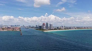 Miami 'de kumsalda güneşli yataklı, okyanus dalgalı bir plaj. Muhteşem manzaralı Miami Beach cenneti. Güney Sahili Miami cankurtaranı. Miami 'de huzurlu deniz kenarı inzivası