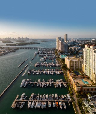 Lüks yatları ve tropikal silueti olan Miami sahilinin havadan görünüşü. Miami kıyısı kıyısı. Sakin bir marina ve turkuaz okyanusta yelkenliler ve yatlar. Lüks yolcu gemisi
