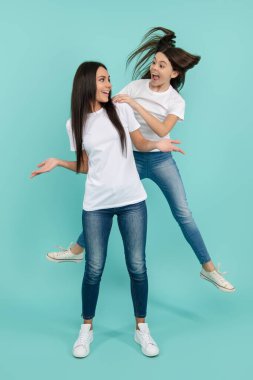 Anne ve kızın atlaması. Enerji ve hareket. Anne ve kızı yükseğe zıplıyorlar. Aile kızlarının heyecanlı mutlu sıçramaları. Çılgın ve eğlenceli anne ve kız. Sıçrama hareketi hissi. Aile atlayışı.