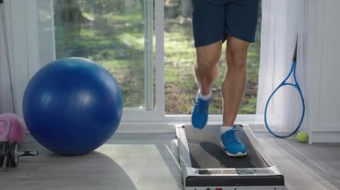 Sporcu spor salonunda yürüme bandında yürüyor. Spor salonunda koşu bandı egzersizi. Yürüme tahtası üzerinde egzersiz yap. Spor erkek ayakları spor yapar. Sporcunun kalori yakma egzersizi var. Spor ayakkabısı ayakları.