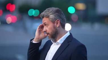 Başı ağrıyan takım elbiseli bir iş adamı. Üzgün adamın ağrıdan dolayı migreni tuttu. Yorgun iş adamı streslidir. Yorgun iş adamı fazla mesai yapıyor ve başı ağrıyor..