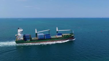 Miami, Florida, ABD - 31 Mayıs 2025: Denize doğru giden konteyner gemisi. Miami 'de konteynırlı kargo gemisi, insansız hava aracı manzaralı. Yük konteynırı kargo gemisine yüklendi. Hava görüntülü kargo gemisi limandan ayrılıyor..