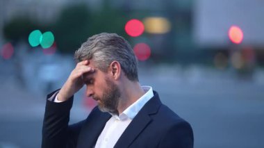 Üzgün adamın ağrıdan dolayı migreni tuttu. Yorgun iş adamı streslidir. Yorgun iş adamı fazla mesai yapıyor ve başı ağrıyor. Başı ağrıyan stresli bir adam. Baş ağrısı olan bir iş adamı..