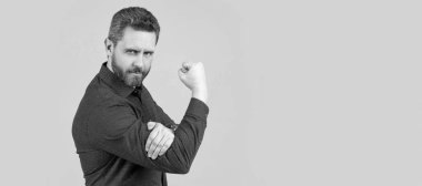 Olgun bir adam L şeklinde kollarını büker, yumruğunu yukarı kaldırır ve müstehcen hareketler yapar. İnsan yüzü portresi, kopyalama alanı olan pankart