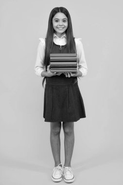 Kopya kitabı olan liseli kız izole edilmiş arka planda poz veriyor. Edebiyat dersi, ilkokul. Entelektüel çocuk okuyucu