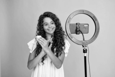 Genç çocuk akıllı telefonuyla sosyal medya için video dersi kaydediyor. Nüfuzlu genç, çevrimiçi yayınlanırken blog için yeni içerik oluşturuyor. Genç bir kızın pozitif ve gülümseyen duyguları