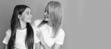 Anne ve kız çocuk afişi, kopyalama alanı, izole edilmiş arka plan. Sevgi dolu, gülümseyen bir kadın mavi arka planda beyaz gömlekli bir kıza sarılıyor.