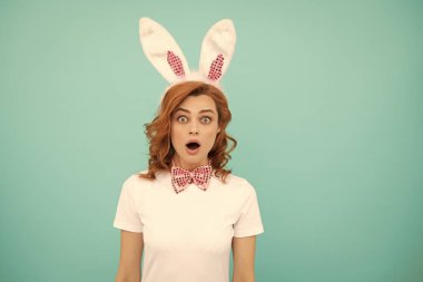 shocked easter woman with bunny ears on blue background.