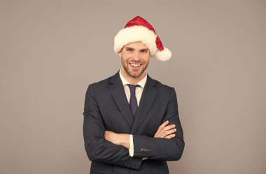 Noel Baba şapkalı mutlu iş adamı gri arka planda, Noel Baba.