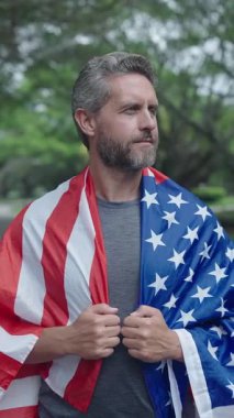 Amerika 'nın Bağımsızlık Günü. 4 Temmuz. İşçi Bayramı ya da 4 Temmuz 'da Amerikan Bayrağı. Amerikan bayrağı ve koşucu. ABD bayrağı. Bağımsızlık Günü. Parkta Amerikan bayrağı taşıyan bir adam..