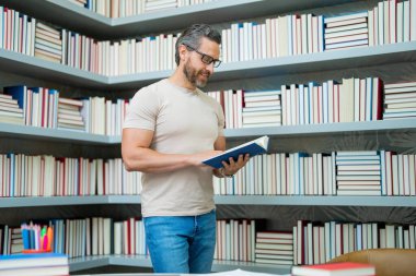 Sınıfta kitabı olan bir öğretmenin portresi. Sınıfta yakışıklı bir öğretmen. Öğretmenler Günü. İyi bir öğretmen. Sınıfta öğretmen. Sınıfta kitapları olan bir erkek öğretmen. Bilgi ve eğitim kavramı