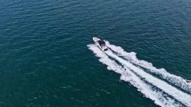 Seyahat güzergahı. Denizde bir tekne. Yat deniz yolculuğuna başlıyor. Denizdeki lüks yatın deniz manzarası. Lüks yat 4K görüntüsü. Yaz tatili. Denizdeki motorlu yat. Tekne gezisi. Hızlı motorlu tekne.