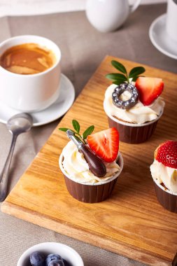 Çilek, yabanmersini ve çikolatadan yapılmış aletlerle süslenmiş kek.