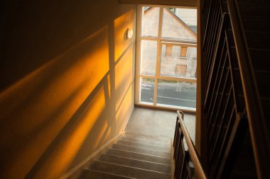 Staircase of apartment building with sunset light playing on the clipart