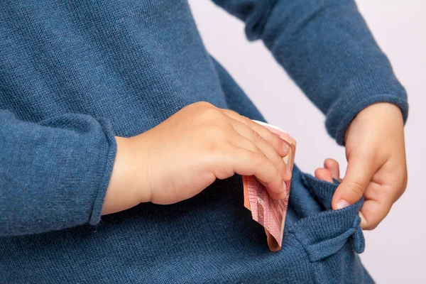 Küçük çocuğun el on euro banknot cebine koyar.