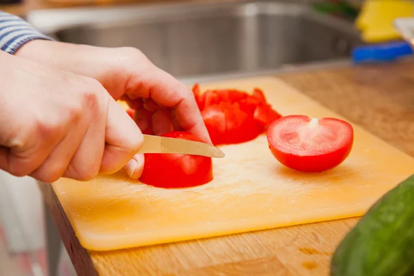 woman cutting tomatoes on a cutting board