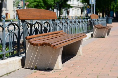 Brown park bench in city center Szeged, Hungary.