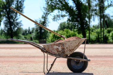 Old cart with shovel. In the background is forest.