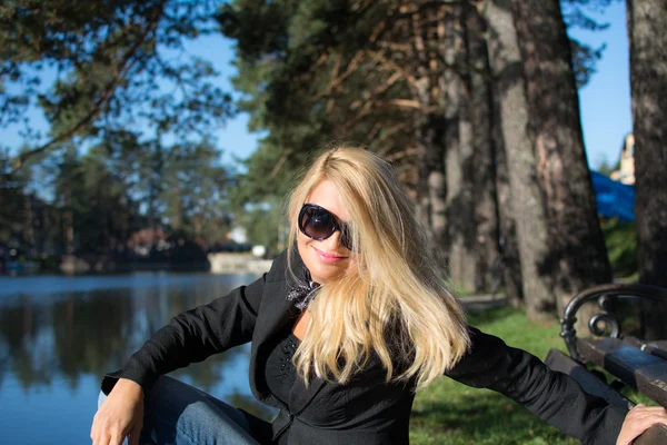 Jovem atraente mulher sexy com belo longo cabelo loiro, de frente para o sol e sorrindo . — Fotografia de Stock