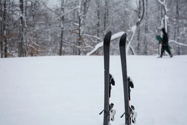 Paisaje invernal en la montaña, esquí en la nieve. Esquiador está pasando con su tabla de snowboard en la mano . —  Fotos de Stock