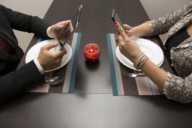 Erkek ve kadın tablet ve cep telefonu kullanarak