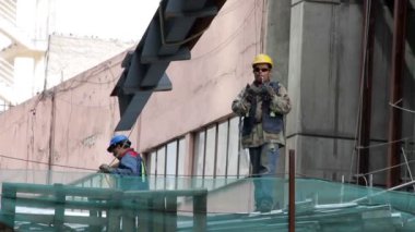 Mexico City, Meksika-Ağustos 2014: İnşaat işçisi büyük bir metal parçası hareketi yönetiyor.