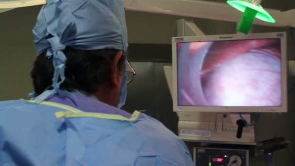 México, 2014: OVER SHOULDER SHOT-HANDHELD SHOT. Cirujano observando un monitor durante una cirugía . — Vídeo de stock
