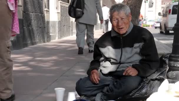 Mexico City, Mexico-August 2014: FULL SHOT. Old man sitting in the sidewalk — Stock Video