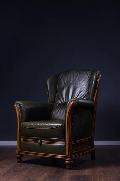 Zielony skórzany fotel naprzeciwko ściany — Zdjęcie stockowe