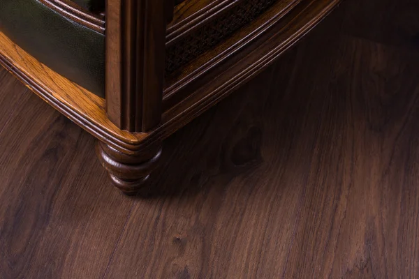 Зеленое кожаное кресло на деревянном полу — стоковое фото