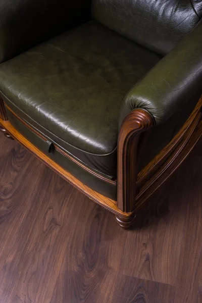 Green leather armchair on a wooden floor — Stock Photo, Image