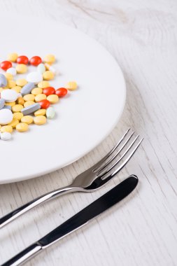 Çatal, bıçak ve hapları ile plaka