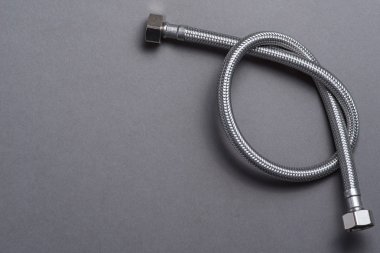 Gri arka plan üzerinde paslanmaz çelik su hortum örgülü