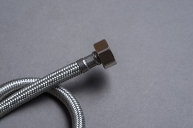 Gri arka plan üzerinde paslanmaz çelik su hortum örgülü