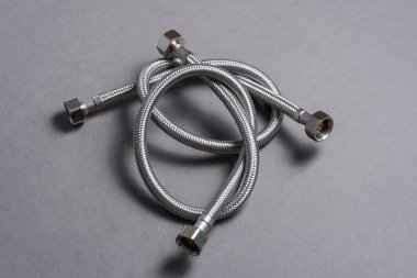 Gri arka plan üzerinde paslanmaz çelik su hortum örgülü