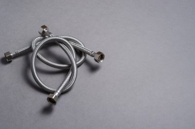 Gri arka plan üzerinde paslanmaz çelik su hortum örgülü