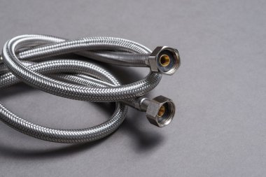 Gri arka plan üzerinde paslanmaz çelik su hortum örgülü