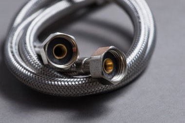 Gri arka plan üzerinde paslanmaz çelik su hortum örgülü