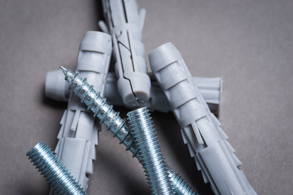 Пластиковые шнурки и винты на темной серой поверхности
