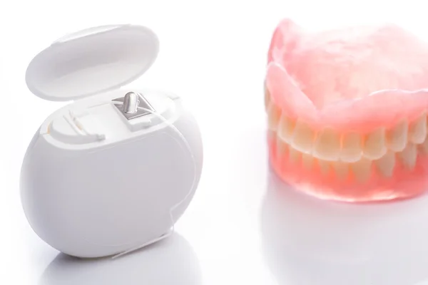 Beyaz arka plan üzerinde diş ipi ile diş modeli — Stok fotoğraf